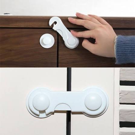 White child safety drawer lock being opened by adult hand on cabinet